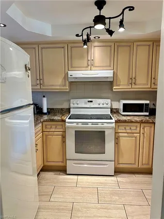 a kitchen with stainless steel appliances granite countertop a stove a sink and a refrigerator