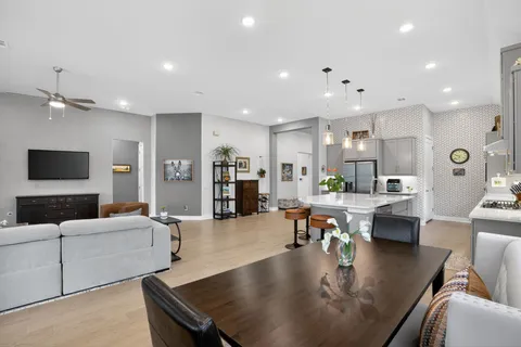 a living room with fireplace furniture and a view of kitchen