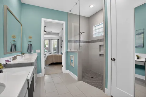 a en suite bathroom with a shower sink and mirror
