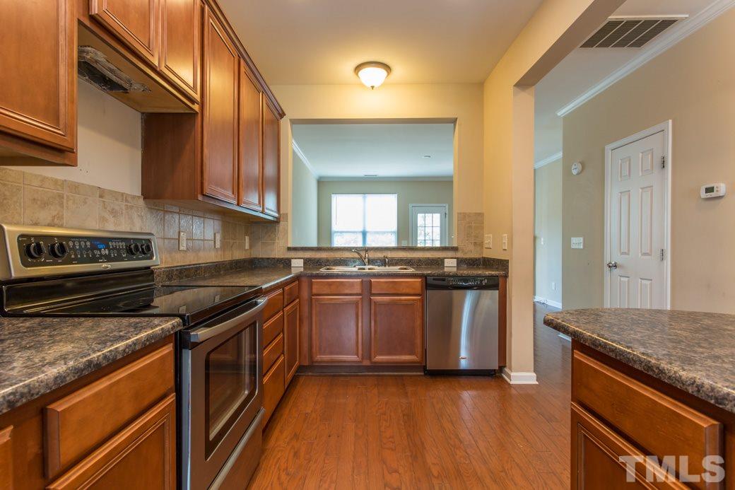 2946 Casona Way Raleigh, NC 27616 - Photo 5 of 25 a kitchen with stainless steel appliances granite countertop a stove a sink and a refrigerator