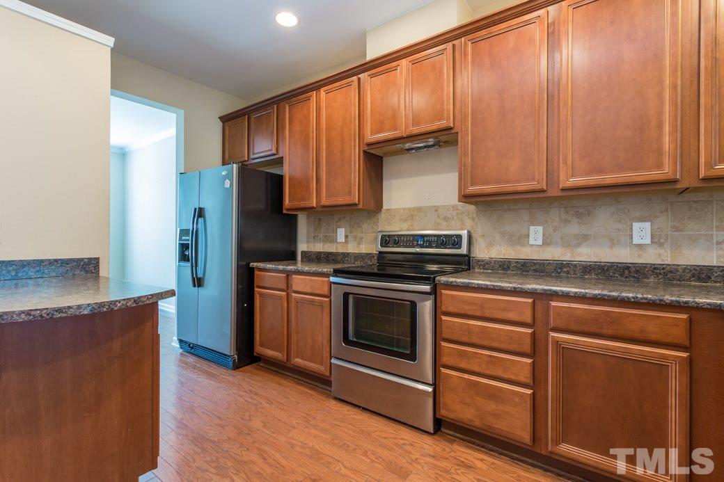 2946 Casona Way Raleigh, NC 27616 - Photo 7 of 25 a kitchen with stainless steel appliances granite countertop a stove a sink and a refrigerator