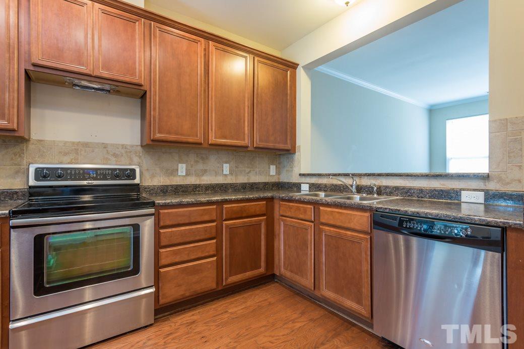 2946 Casona Way Raleigh, NC 27616 - Photo 8 of 25 a kitchen with granite countertop wood cabinets and stainless steel appliances