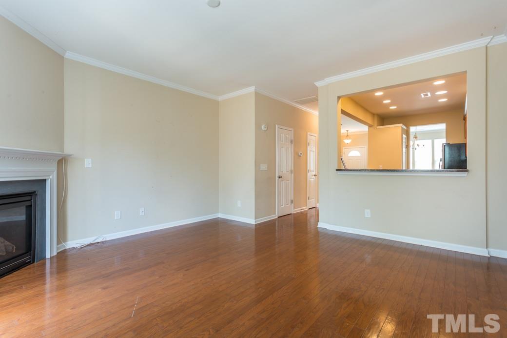 2946 Casona Way Raleigh, NC 27616 - Photo 10 of 25 an empty room with wooden floor and a fireplace