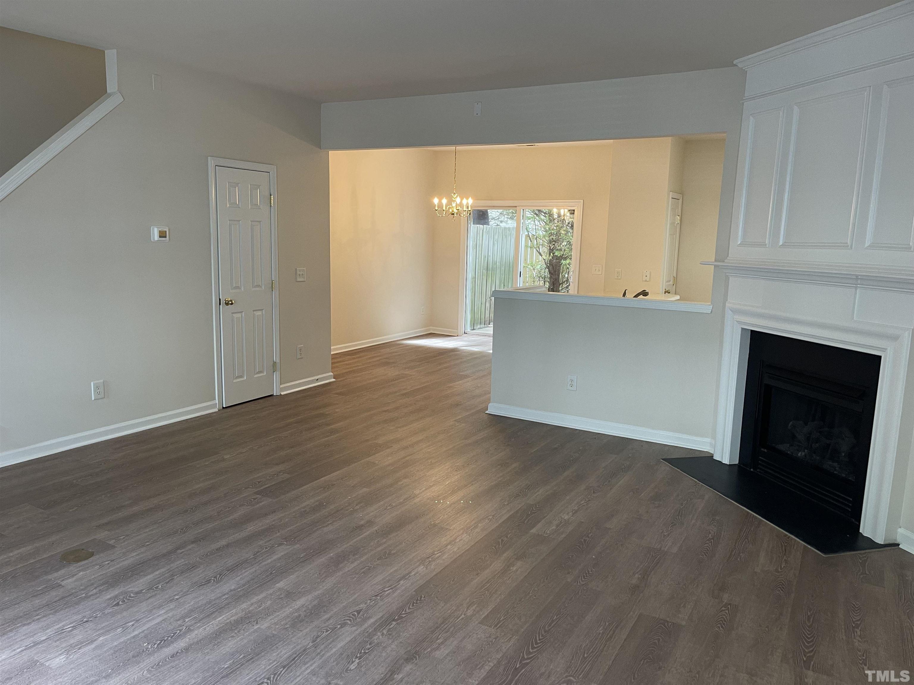 8513 Bright Loop Raleigh, NC 27613 - Photo 7 of 25 a view of an empty room with wooden floor and a window