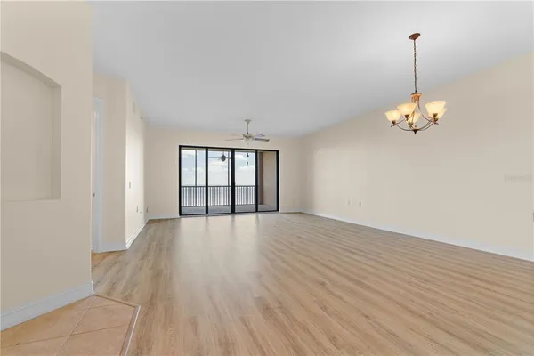 a view of a room with wooden floor and chandelier