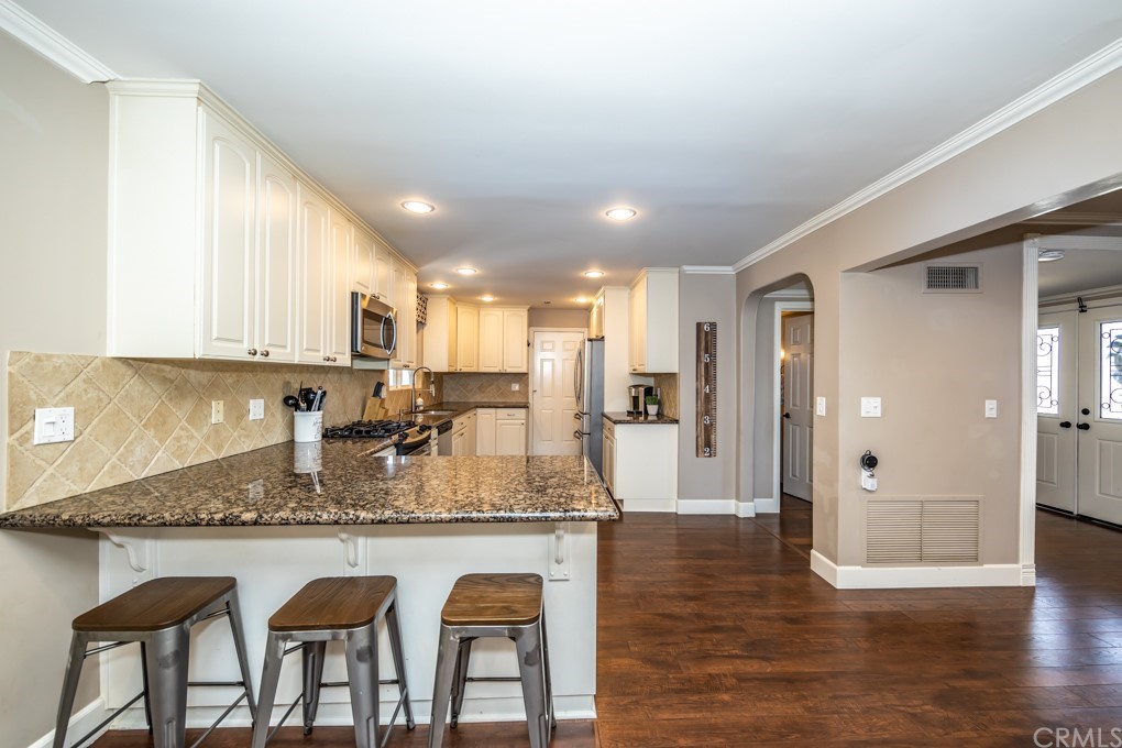 2114 Heloise Way Placentia, CA 92870 - Photo 15 of 61 a kitchen with granite countertop kitchen island wooden cabinets and refrigerator