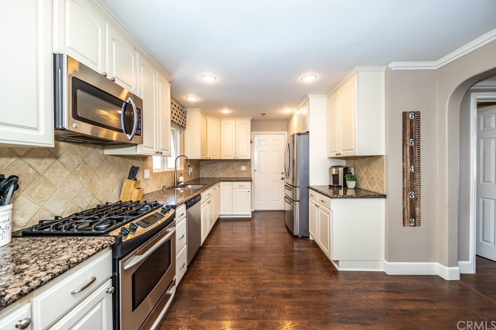 2114 Heloise Way Placentia, CA 92870 - Photo 16 of 61 a kitchen with stainless steel appliances granite countertop a stove top oven a refrigerator a sink and dishwasher with wooden floor