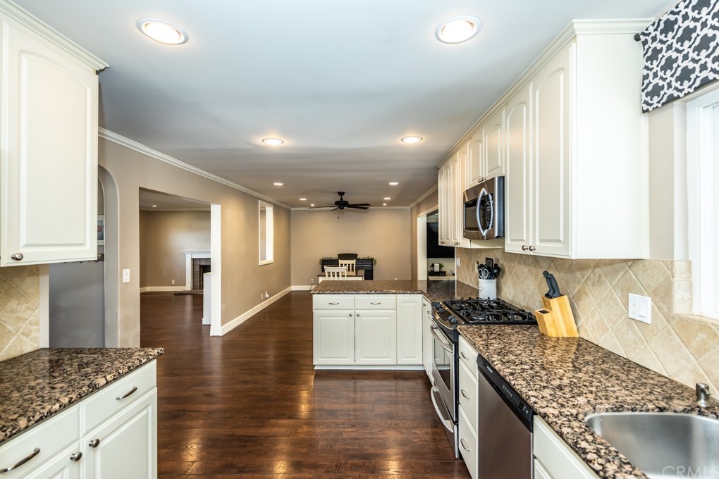 2114 Heloise Way Placentia, CA 92870 - Photo 20 of 61 a kitchen with granite countertop a sink a stove top oven a counter space and cabinets