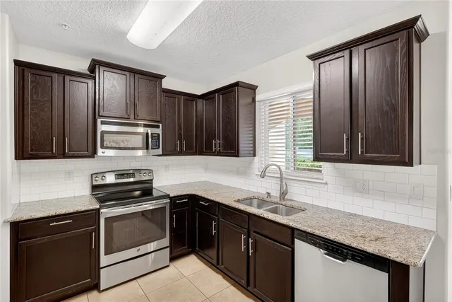 a kitchen with granite countertop stainless steel appliances and wooden cabinets