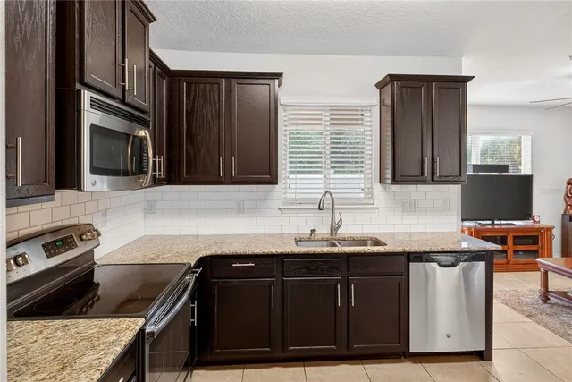 a kitchen with stainless steel appliances granite countertop a sink stove and microwave