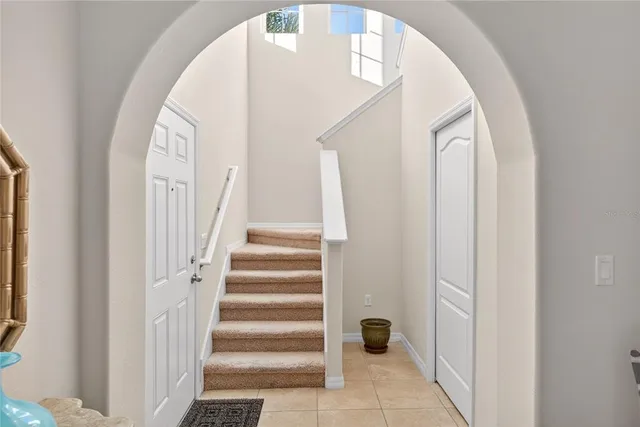 a view of staircase with white walls and white door