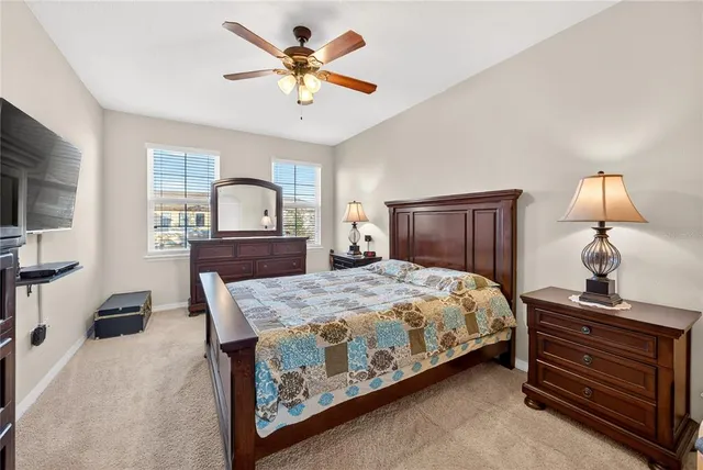 a bedroom with a bed a chandelier and dresser