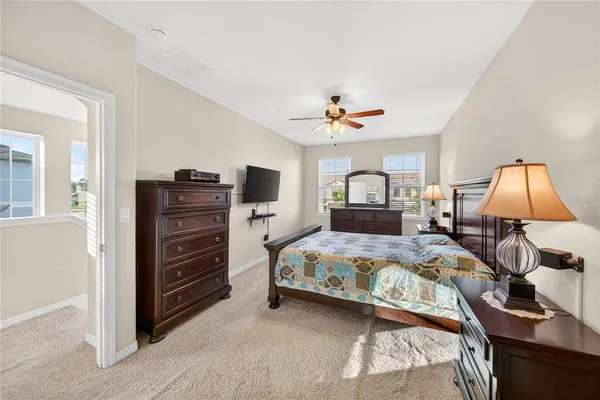 a bedroom with a bed and a lamp on dresser