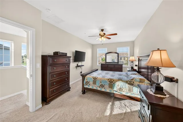 a bedroom with a bed and a lamp on dresser