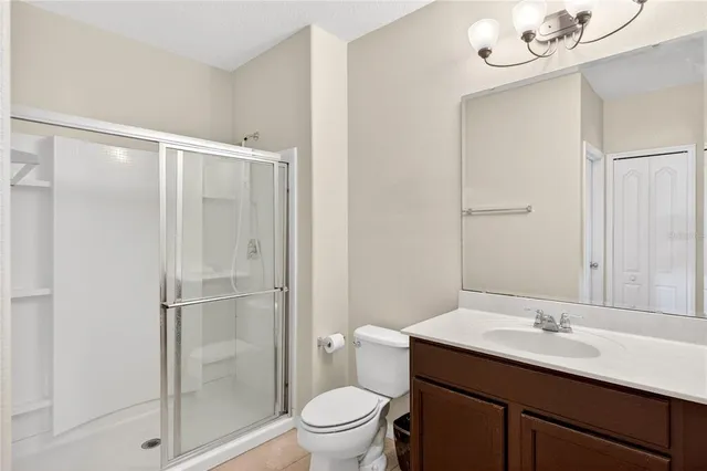 a bathroom with a sink a toilet a mirror and shower