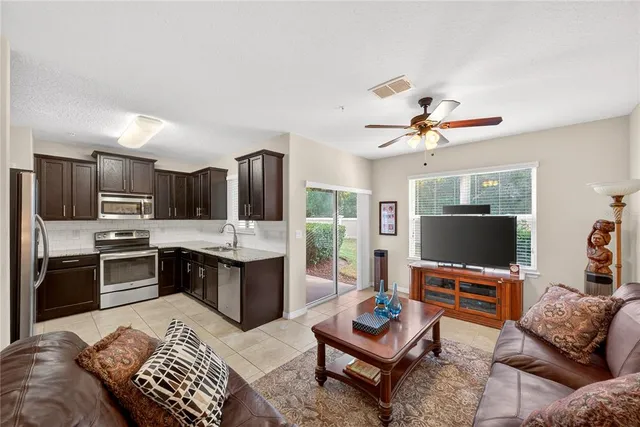 a living room with furniture kitchen view and a flat screen tv