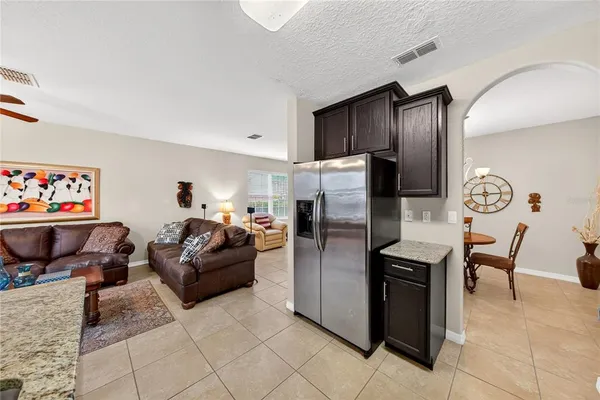 a living room with furniture a refrigerator and a table