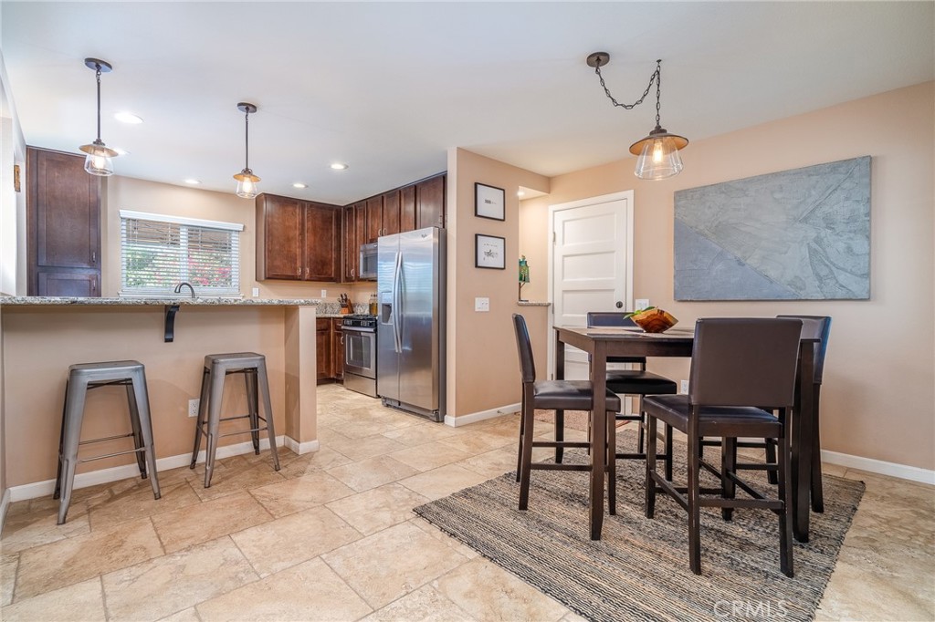 3165 Celeste Drive Riverside, CA 92507 - Photo 8 of 44 a open kitchen with stainless steel appliances granite countertop a table chairs and a refrigerator