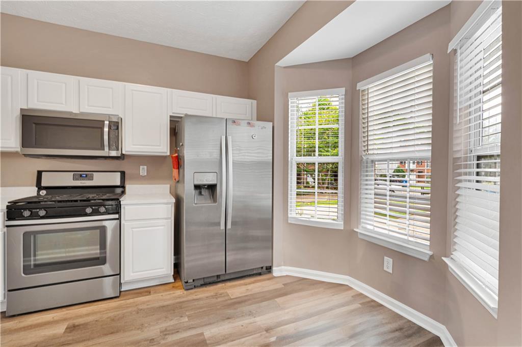4005 Spring Cove Drive Duluth, GA 30097 - Photo 13 of 23 a kitchen with granite countertop a refrigerator and a stove top oven
