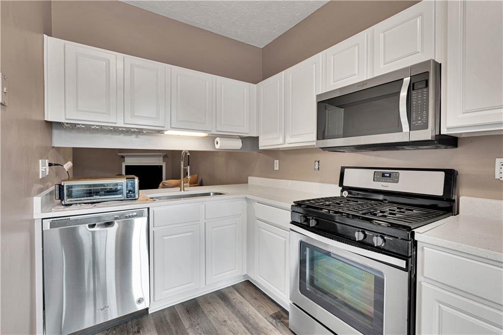 4005 Spring Cove Drive Duluth, GA 30097 - Photo 14 of 23 a kitchen with white cabinets and appliances