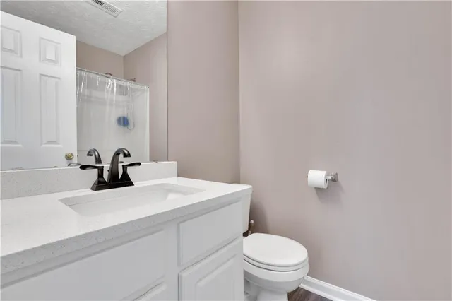 a bathroom with a sink a toilet and mirror