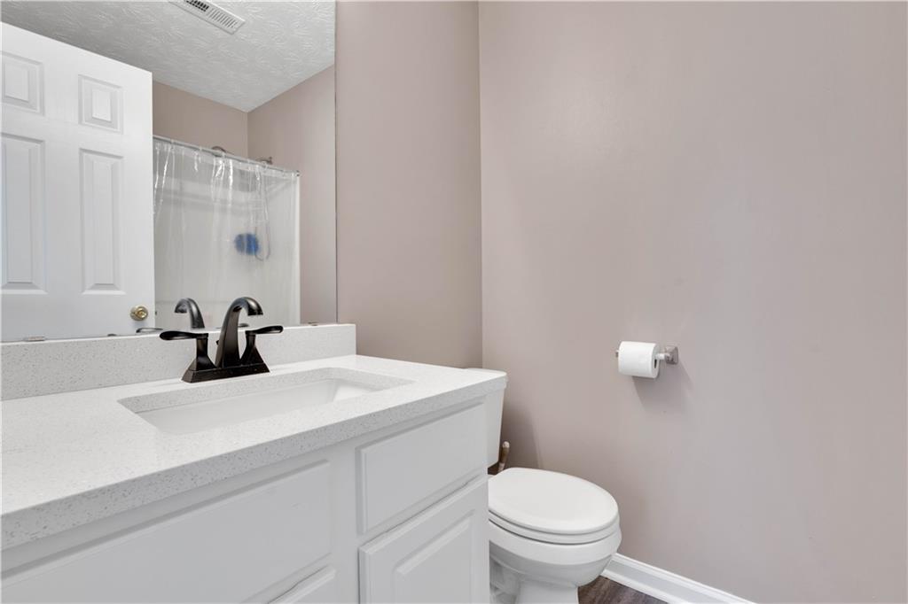 4005 Spring Cove Drive Duluth, GA 30097 - Photo 21 of 23 a bathroom with a sink a toilet and mirror