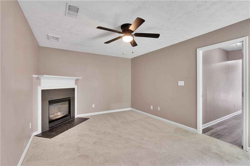 4005 Spring Cove Drive Duluth, GA 30097 - Photo 9 of 23 a view of an empty room with chandelier fan and fire place