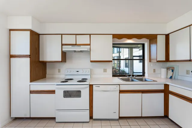 a kitchen with white cabinets and white appliances