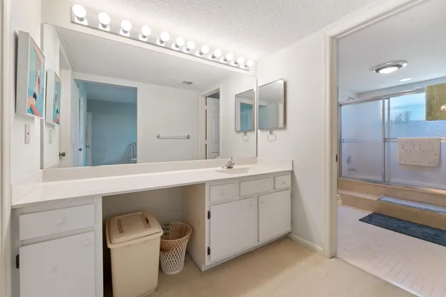 a spacious bathroom with a double vanity sink a mirror and a bathtub