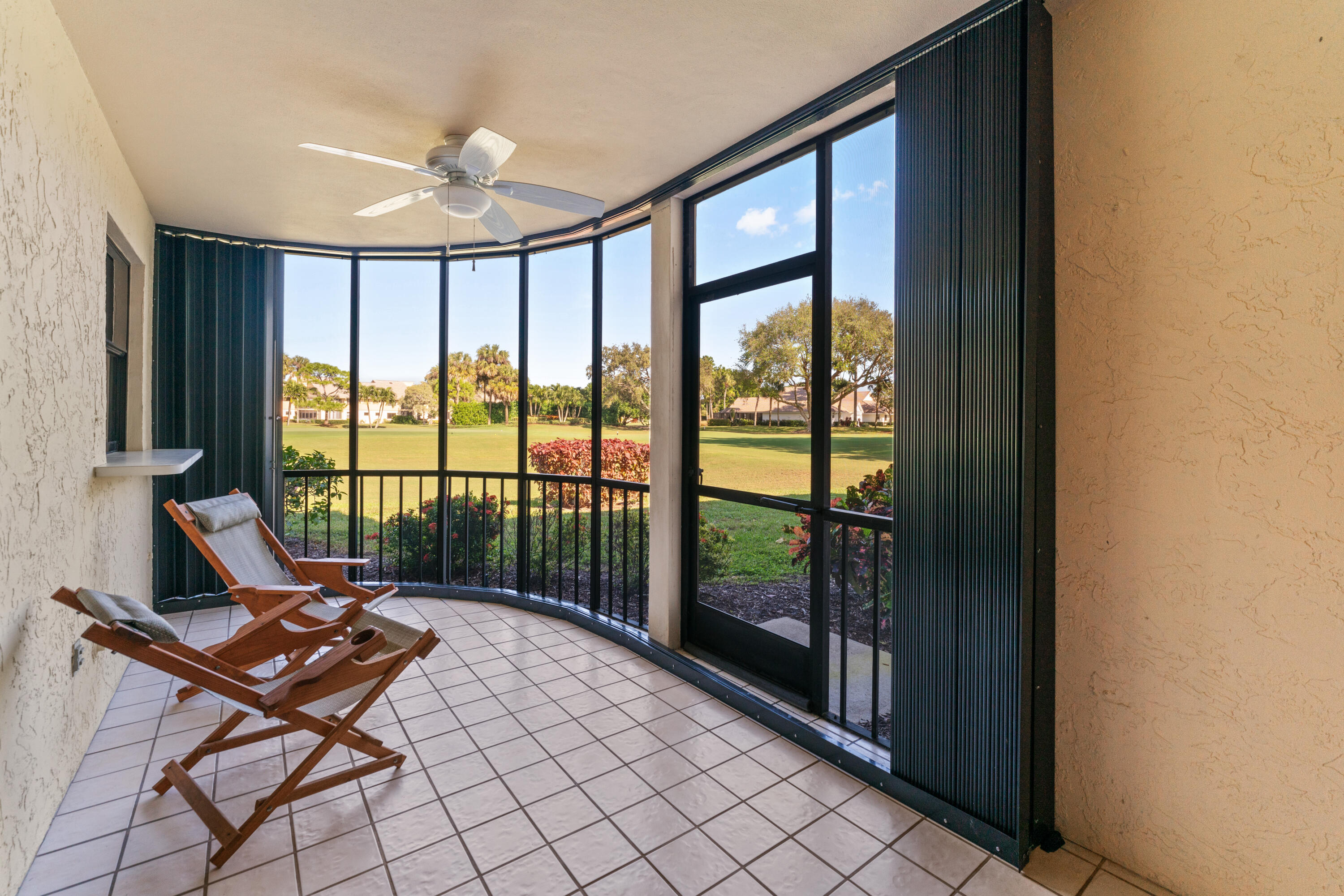 16970 Waterbend Drive, Unit 146 Jupiter, FL 33477 - Photo 26 of 30 a living room with a floor to ceiling window and a table