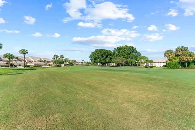 a view of a golf course with an trees in the background