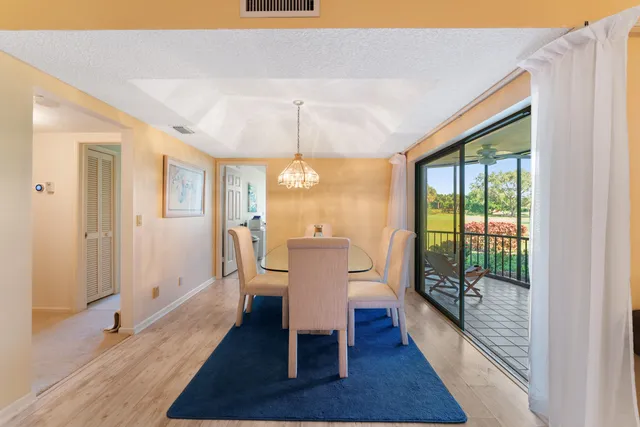 a view of a dining room with furniture a chandelier and wooden floor