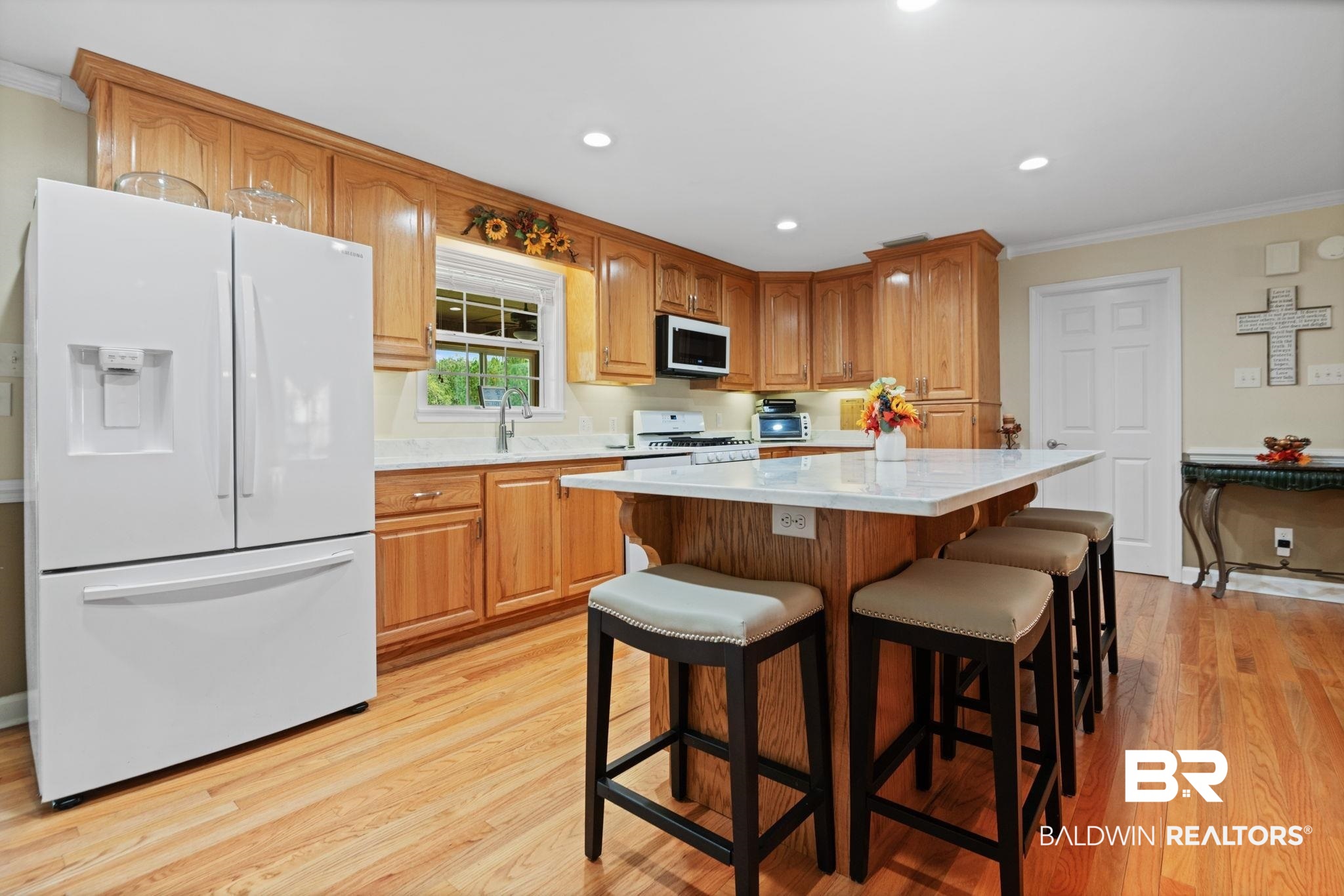 25871 Goat Cooper Road Robertsdale, AL 36567 - Photo 8 of 40 Kitchen featuring a kitchen island, white appliances, light hardwood / wood-style floors, a kitchen bar, and crown molding