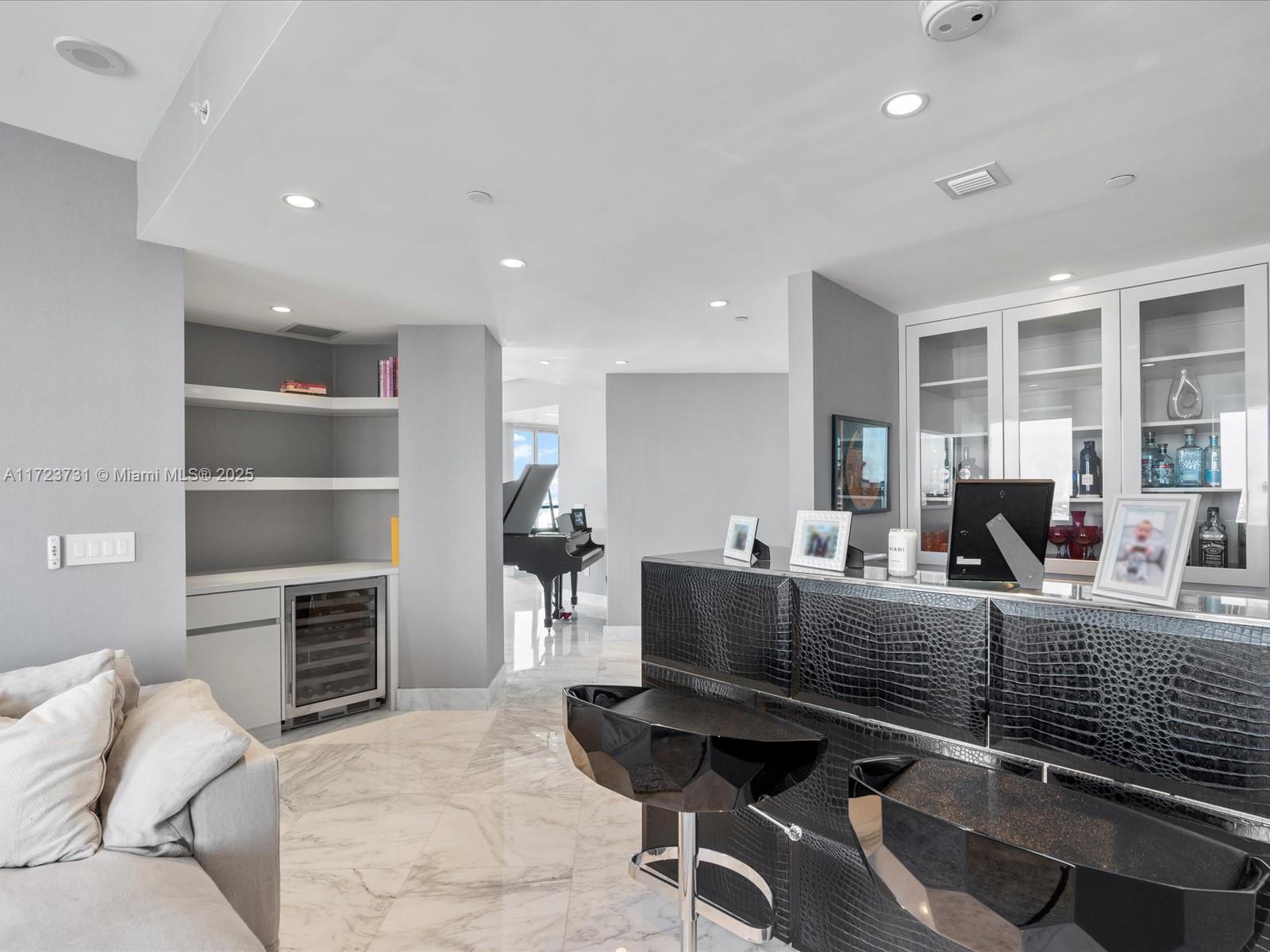 1425 Brickell Avenue, Unit 52BC Miami, FL 33131 - Photo 12 of 72 a living room with furniture a flat screen tv and a refrigerator