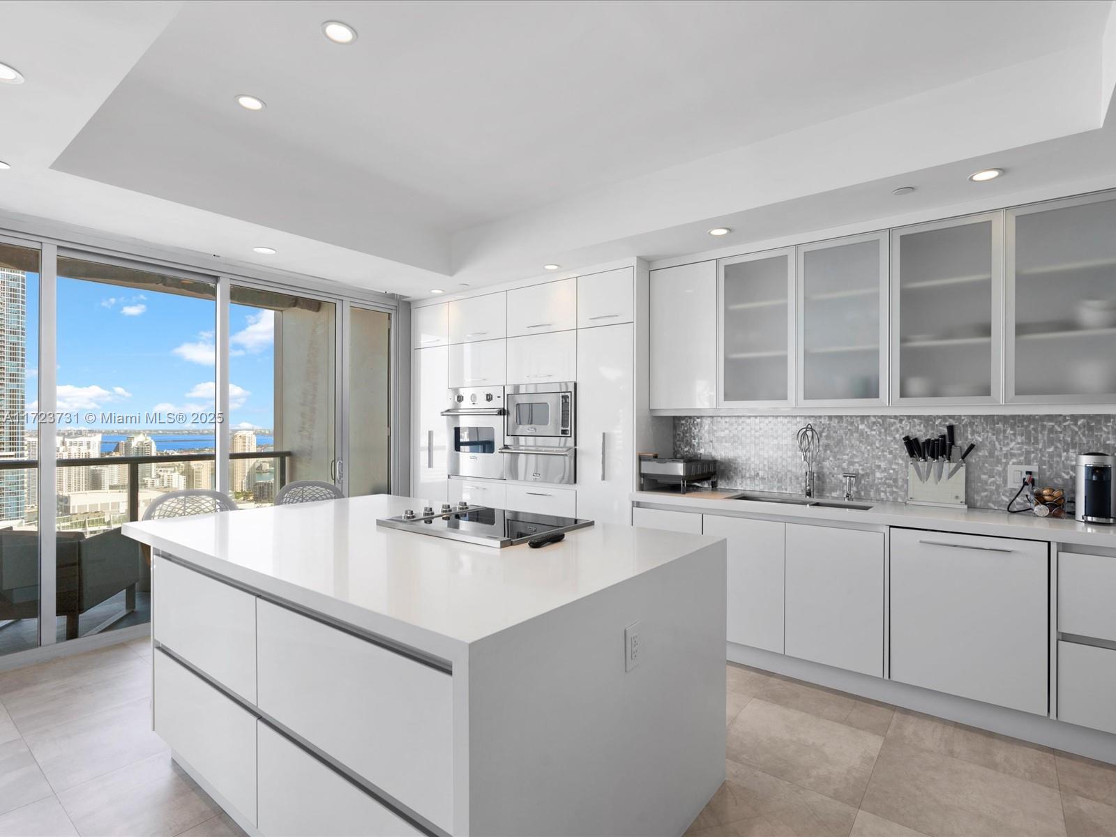 1425 Brickell Avenue, Unit 52BC Miami, FL 33131 - Photo 22 of 72 a kitchen with center island a sink stainless steel appliances and cabinets