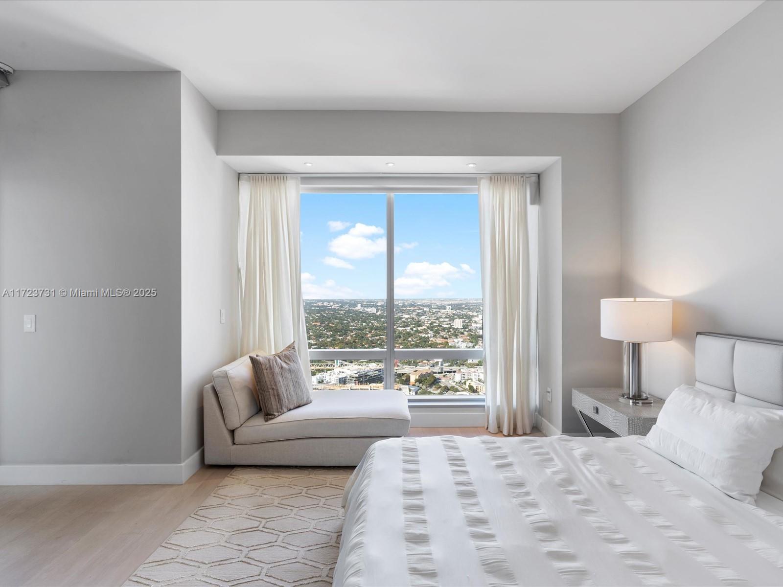 1425 Brickell Avenue, Unit 52BC Miami, FL 33131 - Photo 38 of 72 a bedroom with furniture and a large window