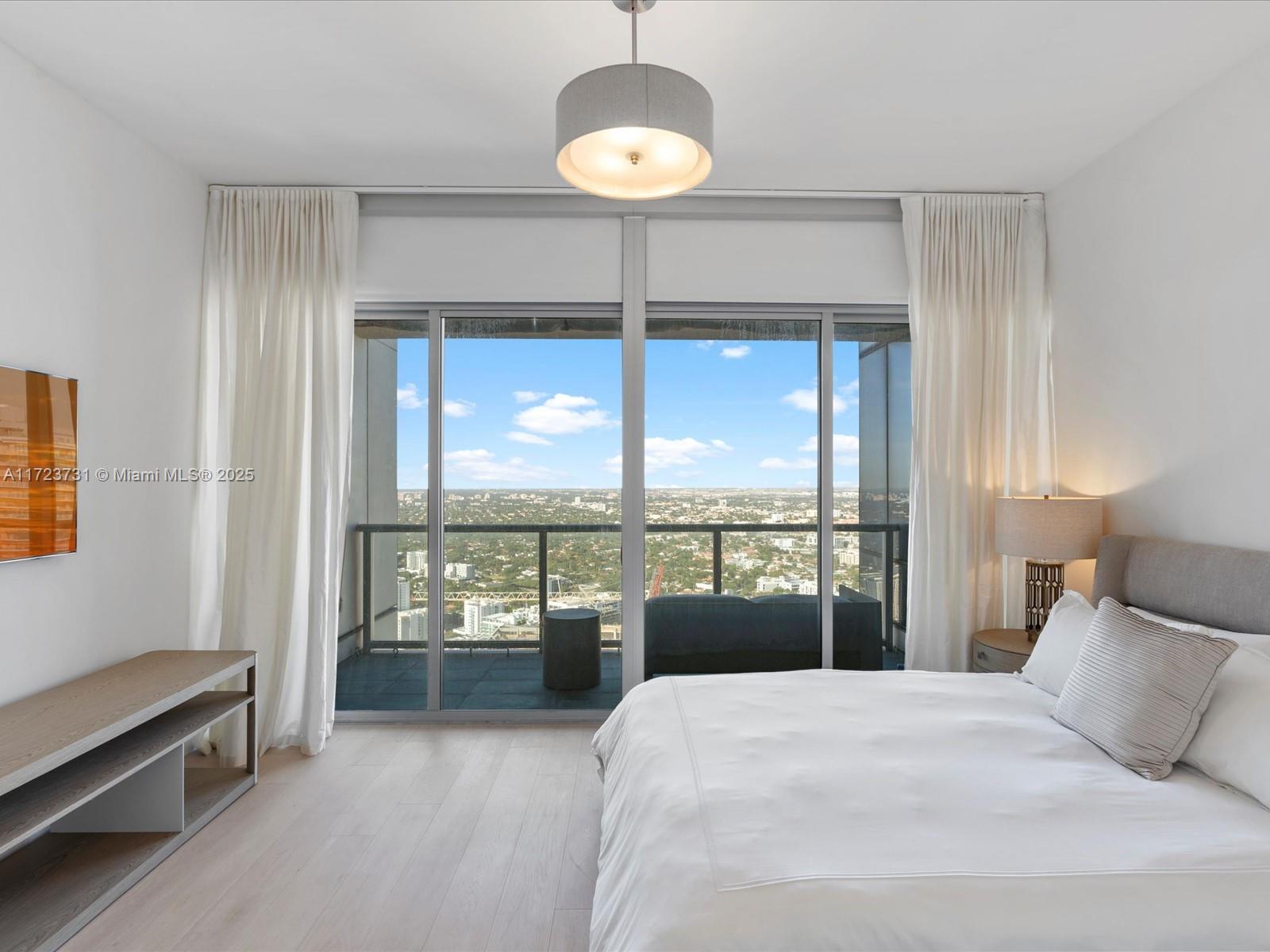 1425 Brickell Avenue, Unit 52BC Miami, FL 33131 - Photo 44 of 72 a bedroom with a bed and a large window