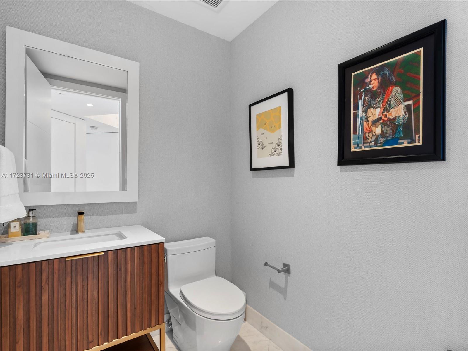 1425 Brickell Avenue, Unit 52BC Miami, FL 33131 - Photo 47 of 72 a bathroom with a toilet a sink and mirror