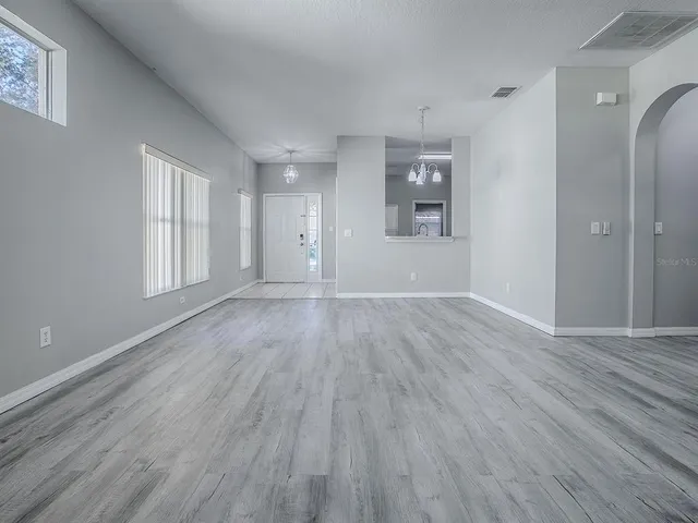 wooden floor in an empty room with a window