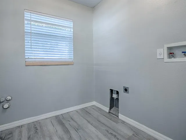 a view of a room with wooden floor and a window