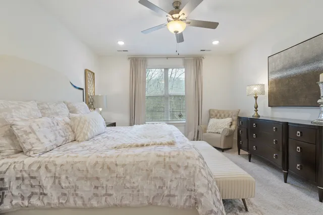 a bedroom with a large bed and a flat tv screen on dresser