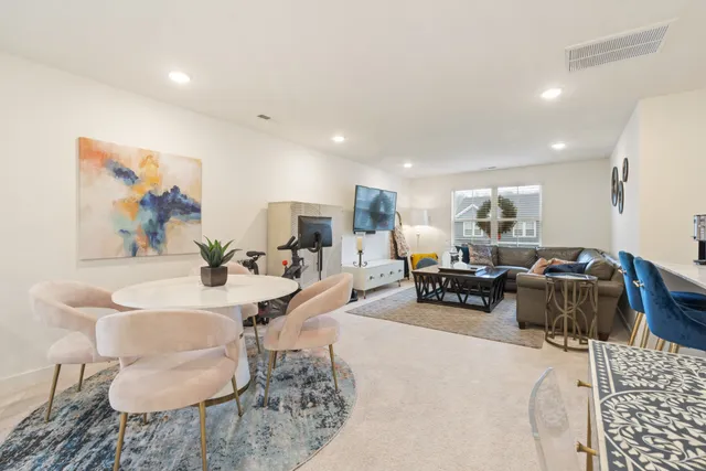 a living room with furniture and a dining table with wooden floor