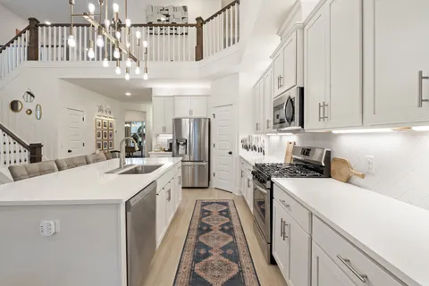 a kitchen with a sink a counter top space stainless steel appliances and cabinets