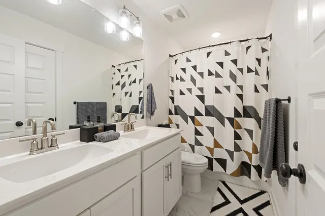 a bathroom with a double vanity sink mirror and shower