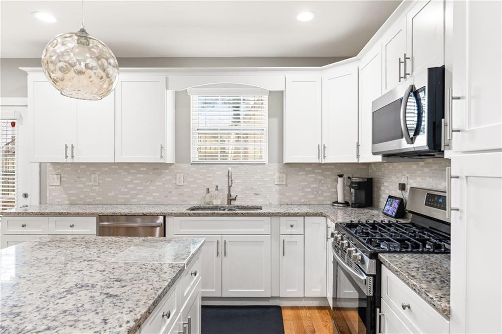 221 Laurel Avenue Southwest Atlanta, GA 30314 - Photo 25 of 29 a kitchen with stainless steel appliances granite countertop a sink stove and cabinets