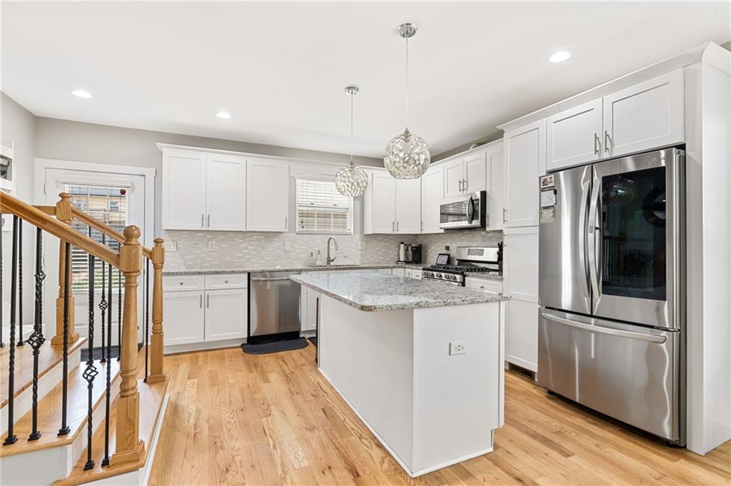 221 Laurel Avenue Southwest Atlanta, GA 30314 - Photo 7 of 29 a kitchen with stainless steel appliances granite countertop a refrigerator a sink dishwasher a stove and white cabinets with wooden floor