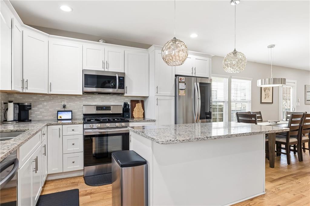 221 Laurel Avenue Southwest Atlanta, GA 30314 - Photo 8 of 29 a large kitchen with stainless steel appliances granite countertop a stove a sink dishwasher a microwave oven with a dining table and chairs