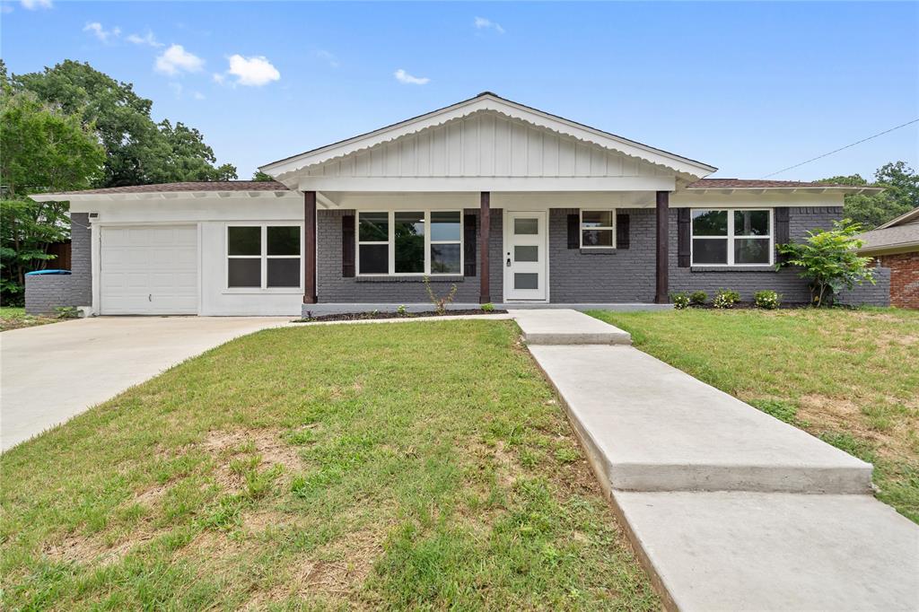 Ranch-style house featuring a garage, brick siding, and a front yard