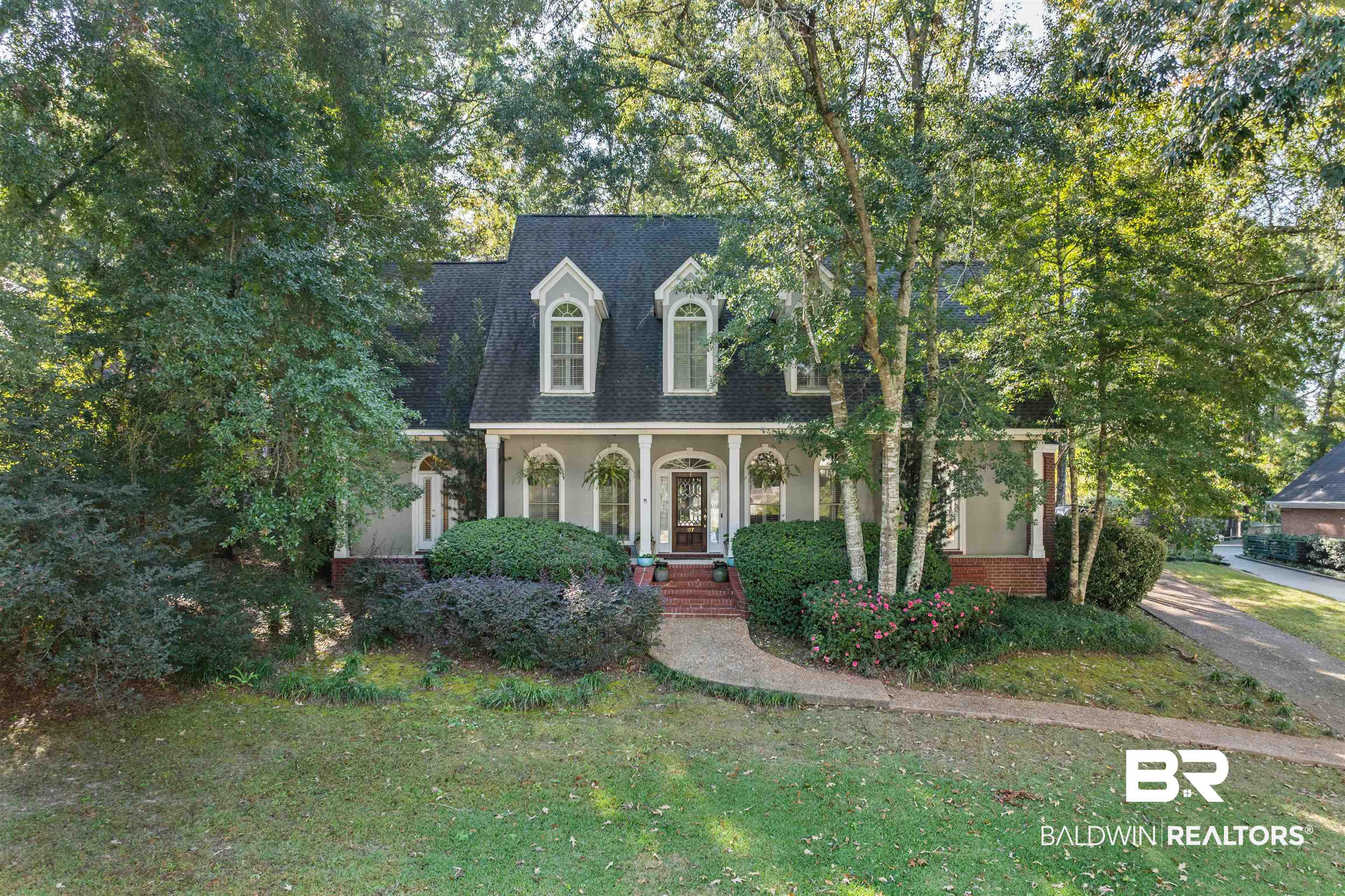 107 Beaver Dam Road Fairhope, AL 36532 - Photo 34 of 45 Cape cod home featuring a front yard, a porch, roof with shingles, and stucco siding