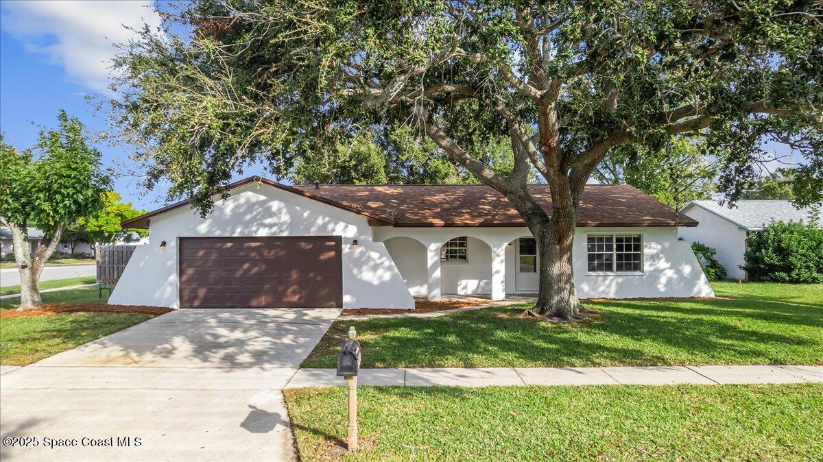 2010 Talloak Road Melbourne, FL 32935 - Photo 1 of 45 a front view of a house with a yard and garage